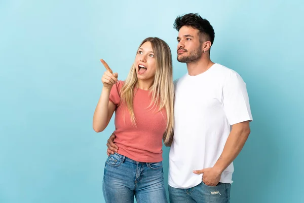 Casal Caucasiano Jovem Isolado Fundo Azul Apontando Dedo Para Lado — Fotografia de Stock