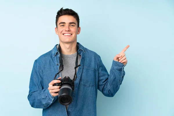 Έφηβος Φωτογράφος Απομονωμένος Μπλε Φόντο Δείχνοντας Δάχτυλο Στο Πλάι — Φωτογραφία Αρχείου