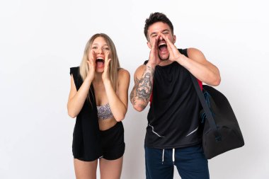 Genç spor çifti beyaz arka planda izole edilmiş bağırıyor ve bir şeyler duyuruyor.