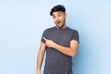 Tarafsız bir geçmişi olan yakışıklı bir Arap. Şaşırmış ve işaret ediyor.