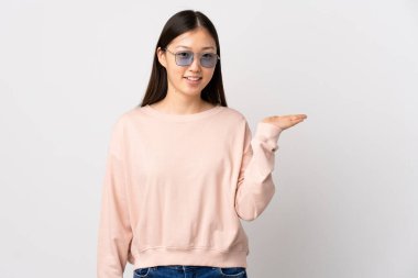 İzole edilmiş beyaz arka plan üzerinde genç Çinli bir kız, bir ilan vermek için avucunun içinde hayali bir fotokopi makinesi tutuyor.