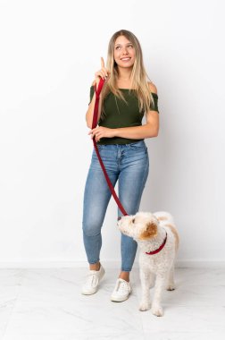 Beyaz arka planda, köpeği gezdiren beyaz bir kadın harika bir fikre işaret ediyor.
