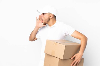 Teslimat yapan Arap adam mavi arka planda izole edilmiş ve ağzı açık bağırıyor.