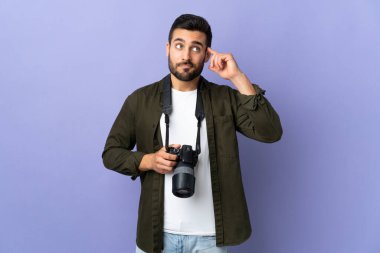 İzole edilmiş mor arka planı olan fotoğrafçı şüpheleri ve düşünceleri var.