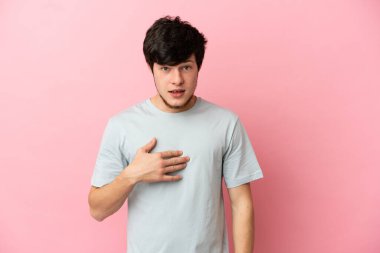 Pembe arka planda izole edilmiş genç bir Rus kendini işaret ediyor.