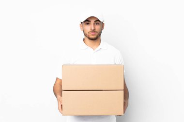 Teslimat yapan Arap adam mavi arka planda izole edilmiş, kollarını kavuşturuyor.