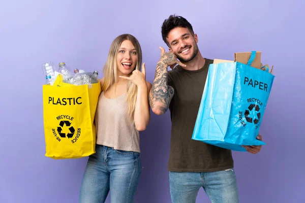 Reciclagem Jovem Casal Caucasiano Isolado Fundo Roxo Fazendo Gesto Telefone — Fotografia de Stock