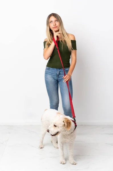 Młoda Kaukaska Kobieta Spacery Pies Izolowany Białym Tle Mając Wątpliwości — Zdjęcie stockowe
