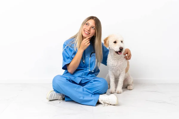 若いです獣医女性とともに犬座って上を見上げながら笑顔 — ストック写真