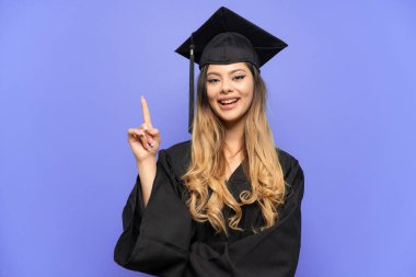 Genç üniversite mezunu Rus kız beyaz arka planda izole edilmiş. Harika bir fikre işaret ediyor.
