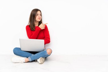 Bilgisayarla çalışan hassas kız beyaz arka planda izole edilmiş, parmak kenarı gösteriyor.