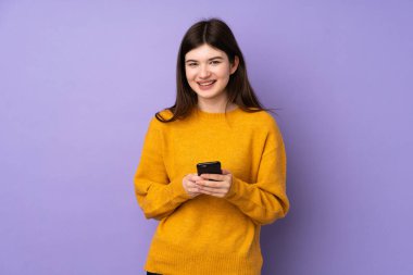 Genç Ukraynalı izole edilmiş mor arka plan kızı cep telefonuyla bir mesaj gönderiyor.