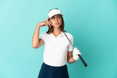 İzole edilmiş mavi arka planda golf oynayan kadının şüpheleri ve düşünceleri var.