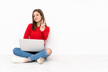 Polisle çalışan hassas kız beyaz arka planda izole edilmiş gülümsüyor ve zafer işareti gösteriyor.