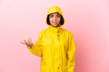 Yağmura dayanıklı bir ceket giyen genç Latin kadın şüpheli hareketler yapıyor.