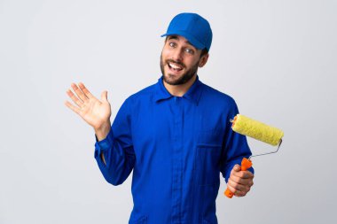 Ressam beyaz arka planda izole edilmiş bir boya silindiri tutuyor ve mutlu bir ifadeyle selamlıyor.