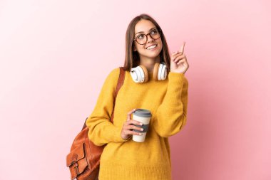 Tecrit edilmiş pembe arka planı olan genç bir bayan harika bir fikre işaret ediyor.