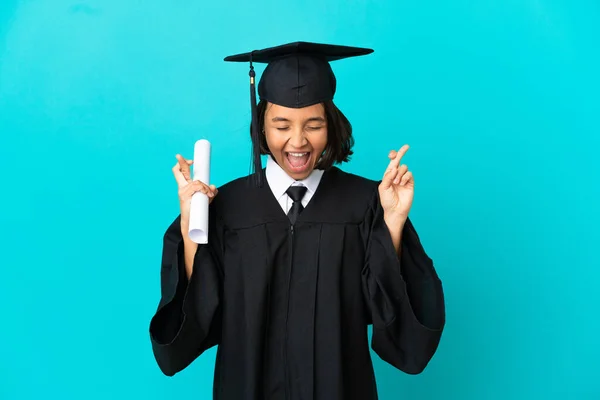 Young University Graduate Girl Isolated Blue Background Fingers Crossing — Stock Photo, Image