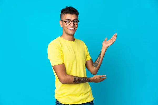 Mladý Brazilský Muž Izolované Modrém Pozadí Natahuje Ruce Stranu Pro — Stock fotografie