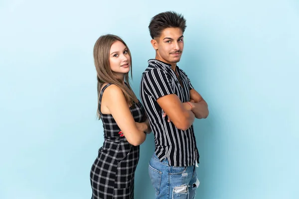 Teenager Caucasian Couple Isolated Blue Background Keeping Arms Crossed Lateral — Stock Photo, Image