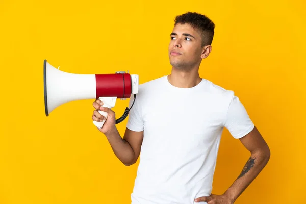 Jonge Braziliaanse Man Geïsoleerd Gele Achtergrond Met Een Megafoon Denken — Stockfoto