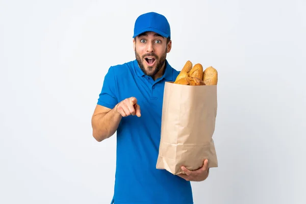 Liefermann Mit Einer Tüte Voller Brote Auf Weißem Hintergrund Überrascht — Stockfoto