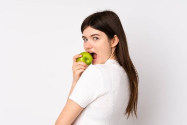 Genç Ukraynalı genç kız izole edilmiş beyaz arka plan üzerinde elma yiyor.