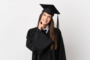 Genç Brezilyalı üniversite mezunu. İzole edilmiş beyaz bir arkaplan. Bir yandan düşünürken bir yandan da...