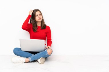 Bilgisayarla çalışan hassas kız beyaz arka planda izole edilmiş, kafası kaşınırken şüpheleri var.