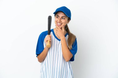 Beyzbol oynayan beyaz tenli genç bir kadın beyaz arka planda izole edilmiş bir şekilde yan tarafa bakıyor ve gülümsüyor.