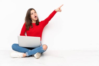 Bilgisayarla çalışan tenaager kız beyaz arka planda izole edilmiş.