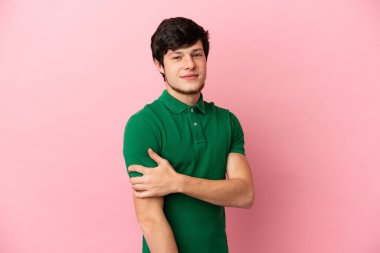 Genç Rus adam pembe arka planda yalnız gülüyor.