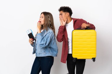 Mavi arka planda izole edilmiş bir bavul tutan gezgin çift ağızları sonuna kadar açık bağırıyor.