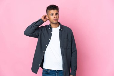 Pembe arka planda izole edilmiş genç Brezilyalı adamın şüpheleri var.