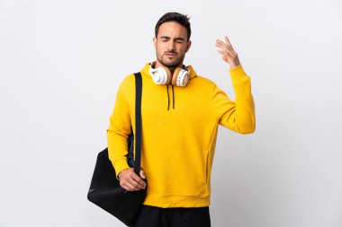 Spor çantalı genç adam yorgun ve hasta bir ifadeyle beyaz arka planda izole edilmiş.