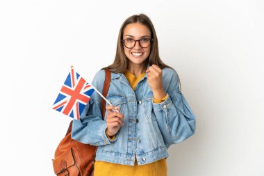 Birleşik Krallık bayrağını tutan genç İspanyol kadın izole edilmiş beyaz arka planda galibiyeti kutluyor.