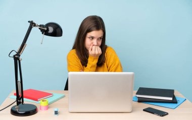 Öğrenci kız evinde çalışıyor. Mavi arka planda izole edilmiş. Şüpheleri var.