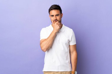 Mor arka planda izole edilmiş genç yakışıklı adamın şüpheleri var.