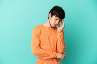 Genç Rus adam mavi arka planda baş ağrısı ile izole edildi.