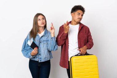 Mavi arka planda izole edilmiş bir bavul taşıyan gezgin çift şans diliyor ve en iyisini diliyor.