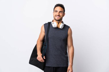 Spor çantalı genç adam beyaz arka planda izole edilmiş bir şekilde yukarı bakarken bir fikir düşünüyor.
