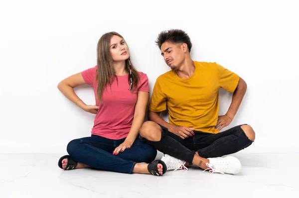 Young Couple Sitting Floor Isolated White Background Suffering Backache Having — Stock Photo, Image