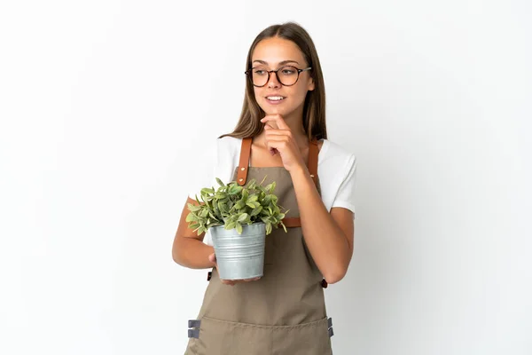 Kertész Lány Gazdaság Egy Növény Felett Elszigetelt Fehér Háttér Néz — Stock Fotó