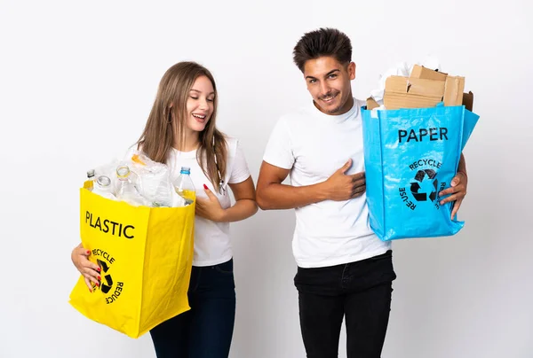 Pareja Joven Sosteniendo Una Bolsa Llena Plástico Papel Aislado Sobre —  Fotos de Stock