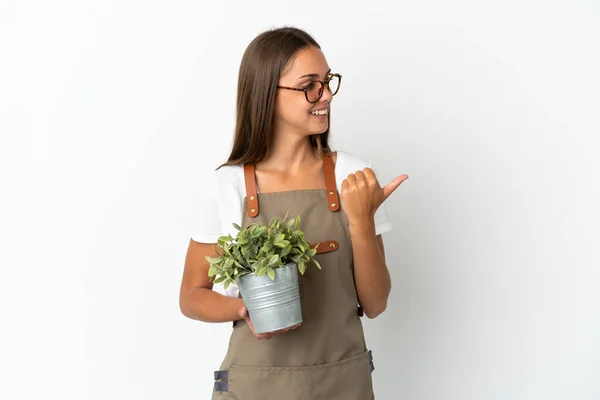 Tuinmeisje Met Een Plant Geïsoleerde Witte Achtergrond Wijzend Naar Zijkant — Stockfoto