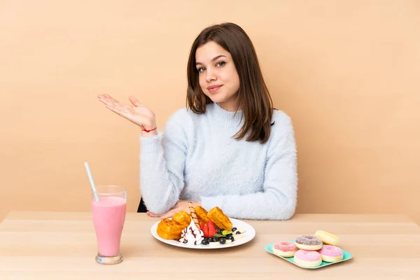 Chica Adolescente Comiendo Gofres Aislados Sobre Fondo Beige Sosteniendo Espacio — Foto de Stock
