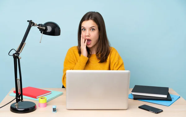 Student girl studying in her house isolated on blue background with surprise and shocked facial expression