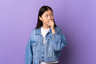 Soyutlanmış mor bir geçmişi olan genç bir Çinli kızın şüpheleri ve kafa karıştırıcı bir yüz ifadesi var.