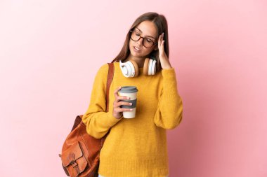 Pembe arka planda, baş ağrısı olan genç bir kız öğrenci.