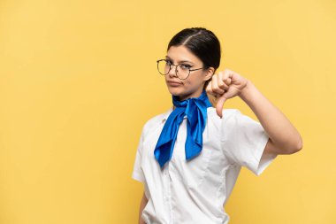 Uçak hostesi sarı arka planda izole edilmiş, başparmağında negatif ifade var.